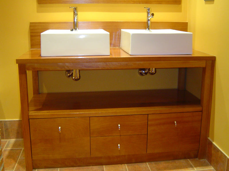 Mueble de madera con dos lavabos sobre encimera